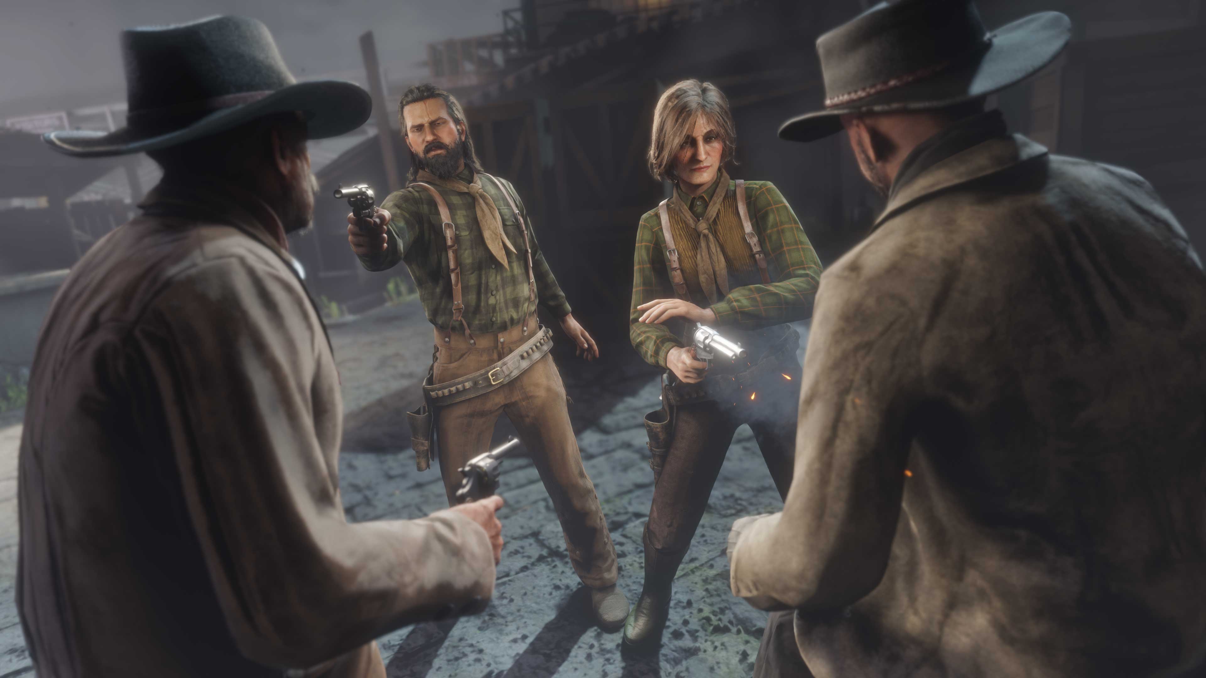 Dois personagens de Red Dead Online vestidos com o traje inspirado na comunidade atiram em direção a dois personagens armados nas proximidades.